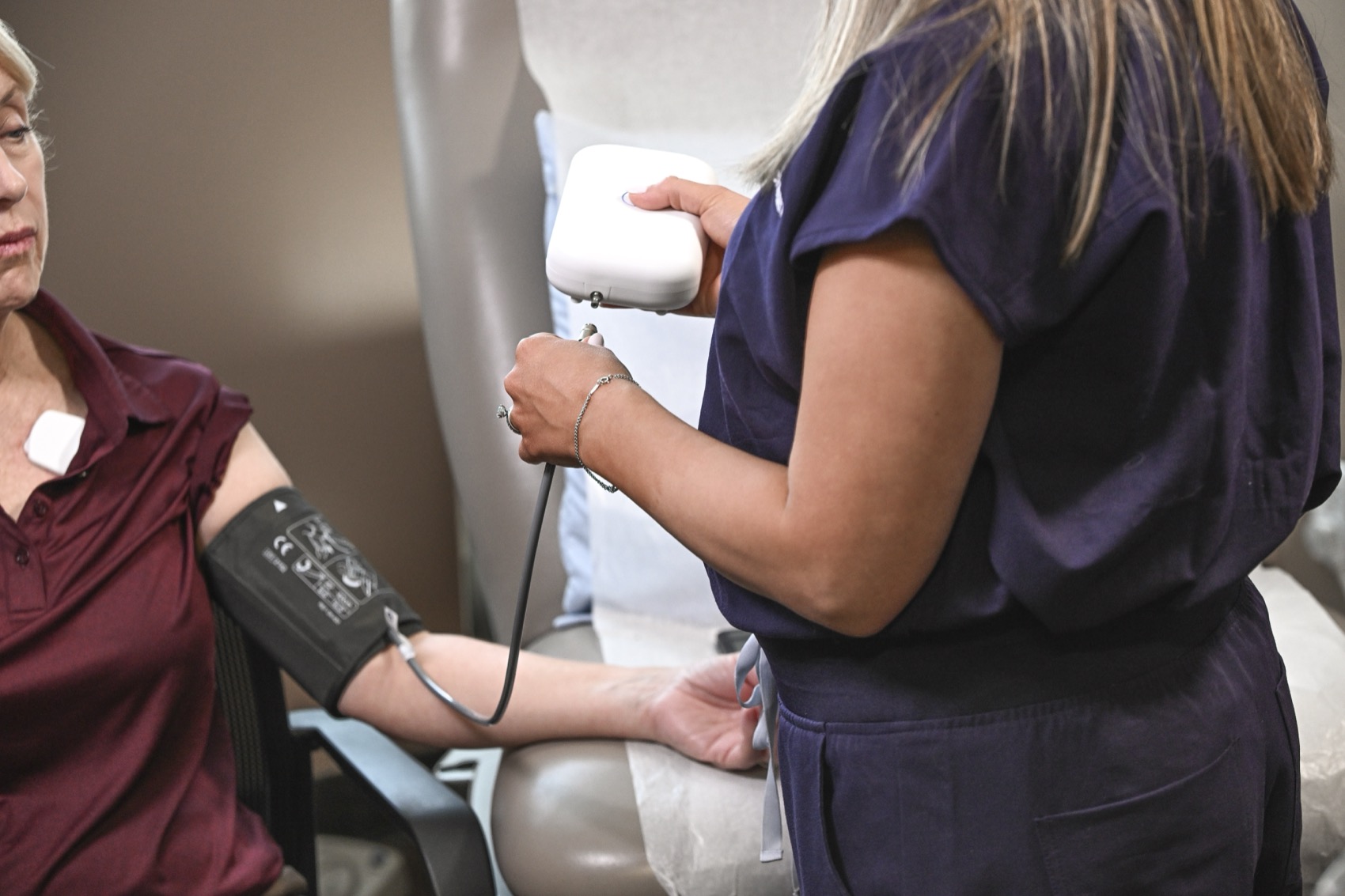 A clinician using the Vivio System arm-cuff device with a patient