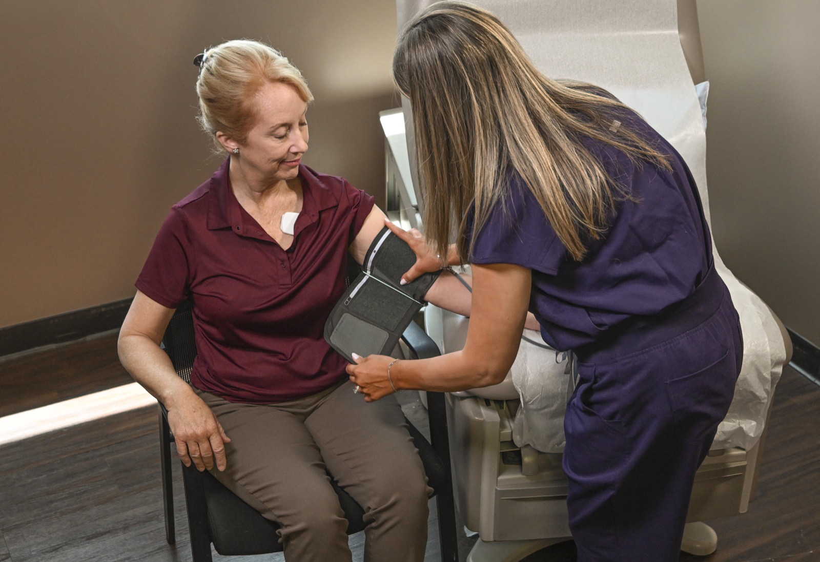 A clinician fitting the Vivio System arm cuff on a patient